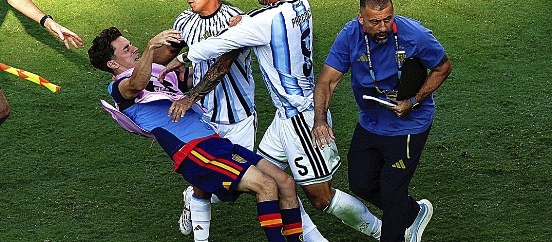 El jugador español Gavi, a la izquierda, es empujado en un choque con el jugador argentino Leandro Paredes (5) y Thiago Almada tras la final del Mundial entre España y Argentina en East Rutherford, Nueva Jersey, cerca de Nueva York, el domingo 19 de julio de 2026. (AP Foto/Yuki Iwamura)