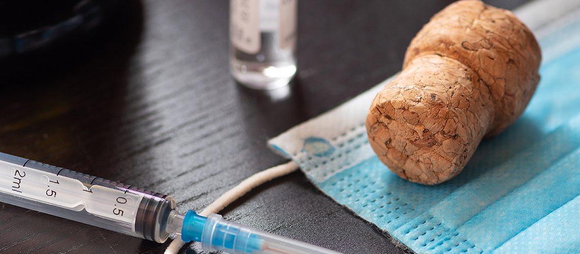 Syringe, vial, surgical face mask and cork. New year concept during Covid19 or Coronavirus emergency, no party